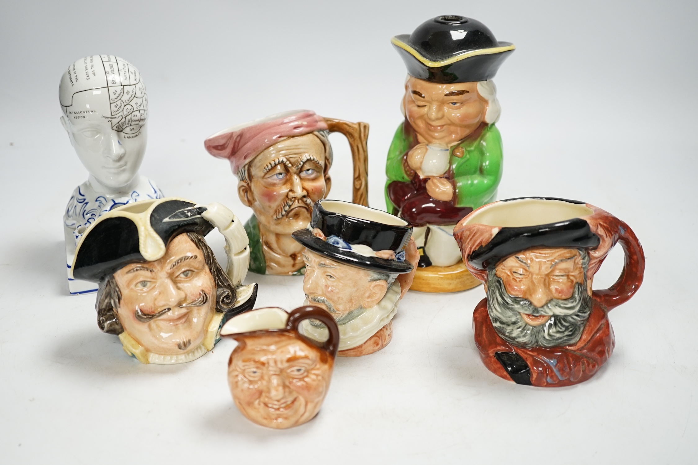 An F. Bridges Phrenology head inkstand, four Royal Doulton Toby jugs, two others, a phrenology bust and a framed pietra dura panel, tallest 17cm. Condition - poor to good, bust broken and re-glued